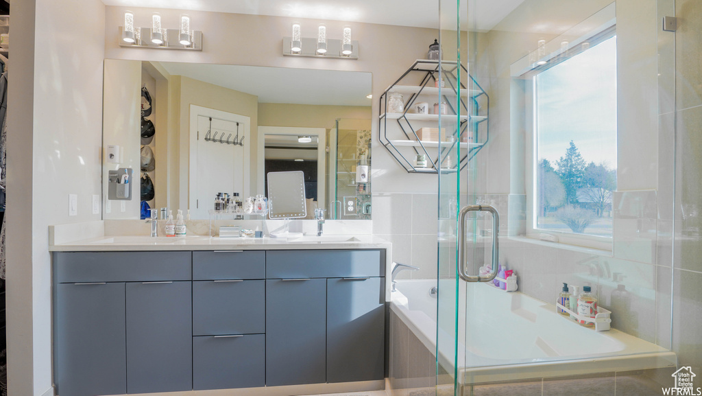 Bathroom featuring large vanity, independent shower and bath, and double sink