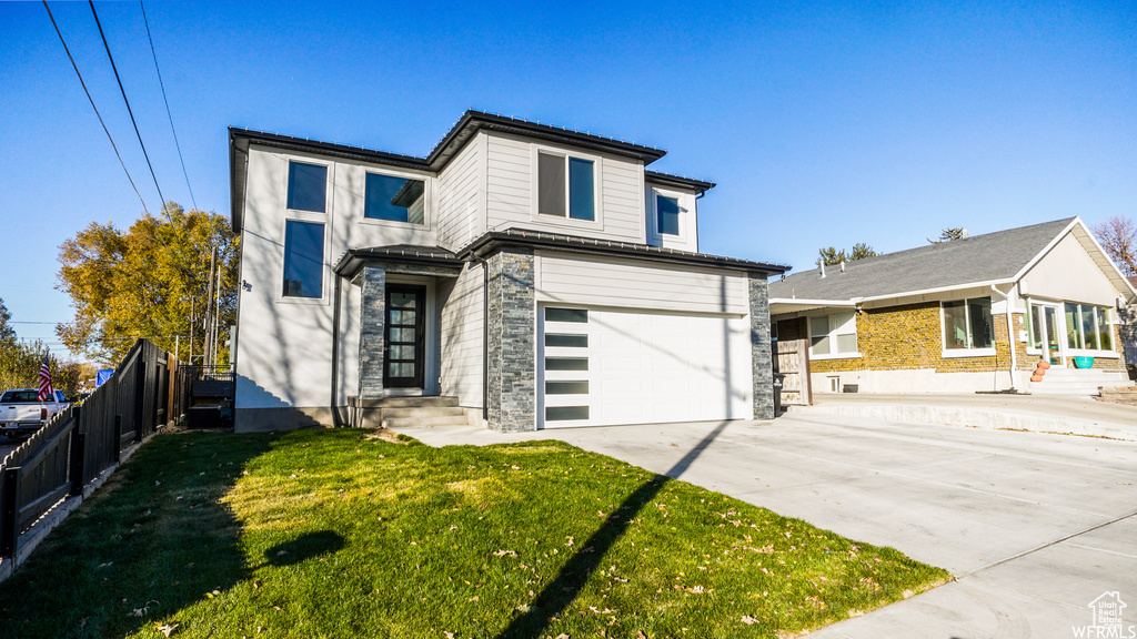 View of front of property featuring a garage and a front yard