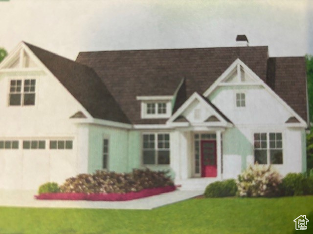 View of front of house with a garage and a front lawn