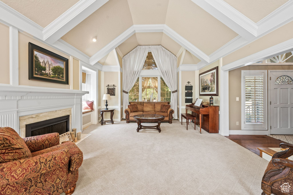 Carpeted living room with crown molding, lofted ceiling with beams, and a premium fireplace