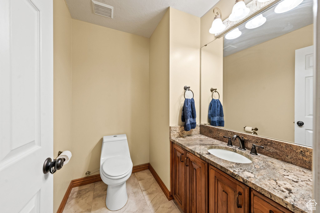 Bathroom with vanity, toilet, and tile floors