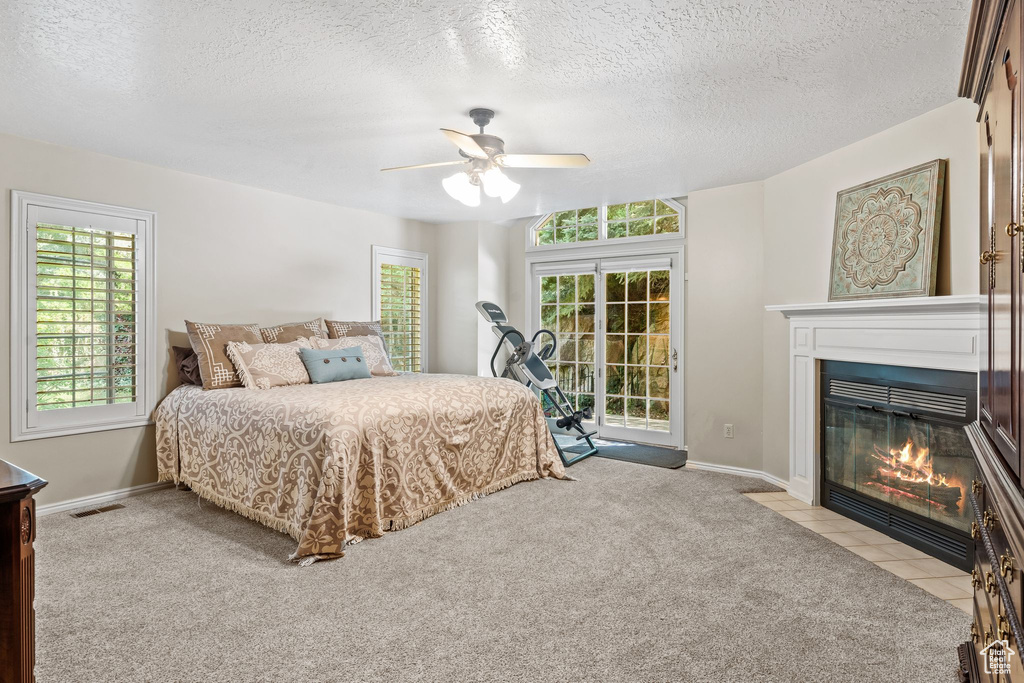 Carpeted bedroom featuring a textured ceiling and ceiling fan