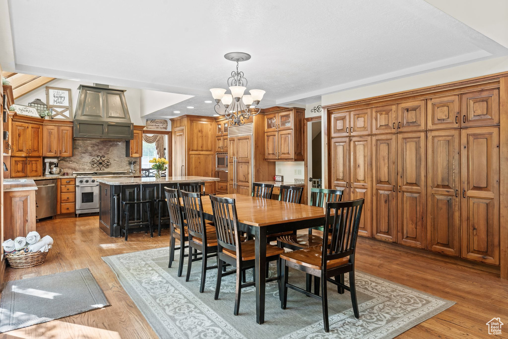 Dining space with light hardwood / wood-style floors and an inviting chandelier