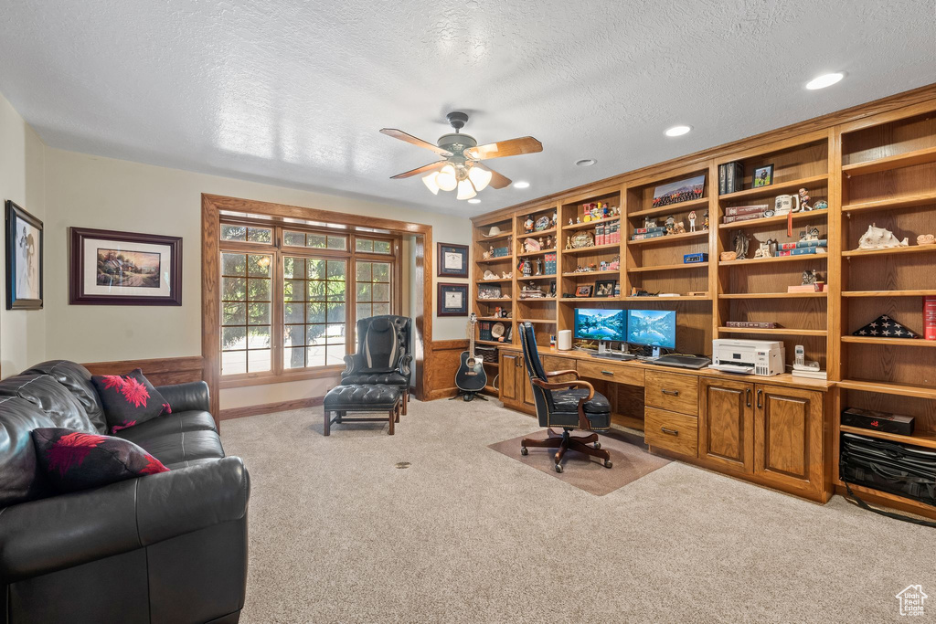 Carpeted office space with ceiling fan and a textured ceiling