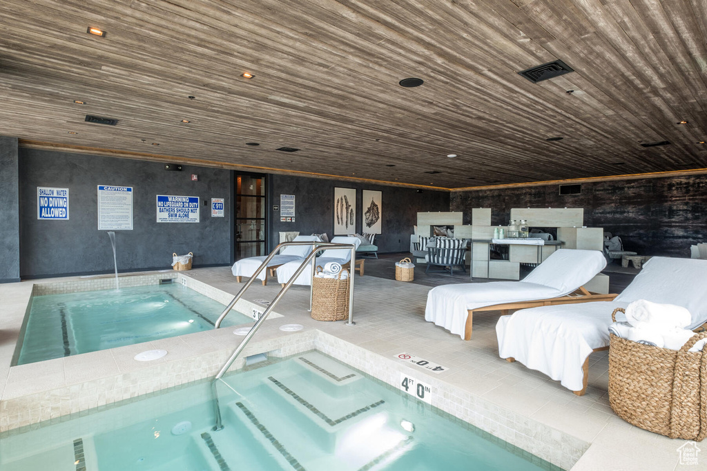 View of swimming pool featuring an indoor hot tub