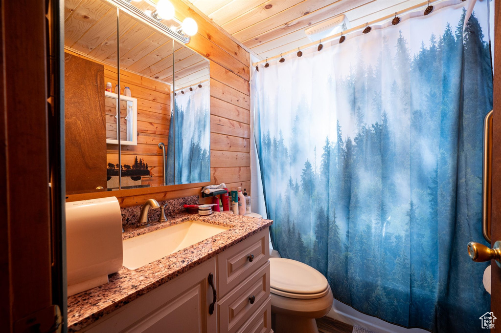 Bathroom with oversized vanity, wooden walls, and wood ceiling