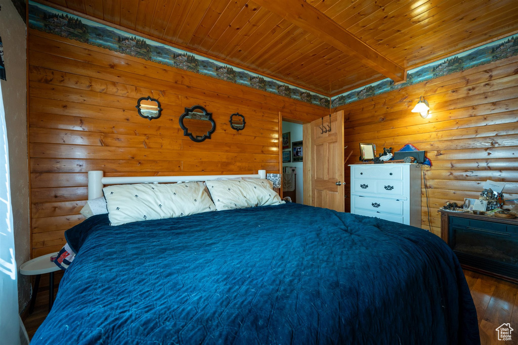 Bedroom with beam ceiling, dark wood-type flooring, and wood ceiling