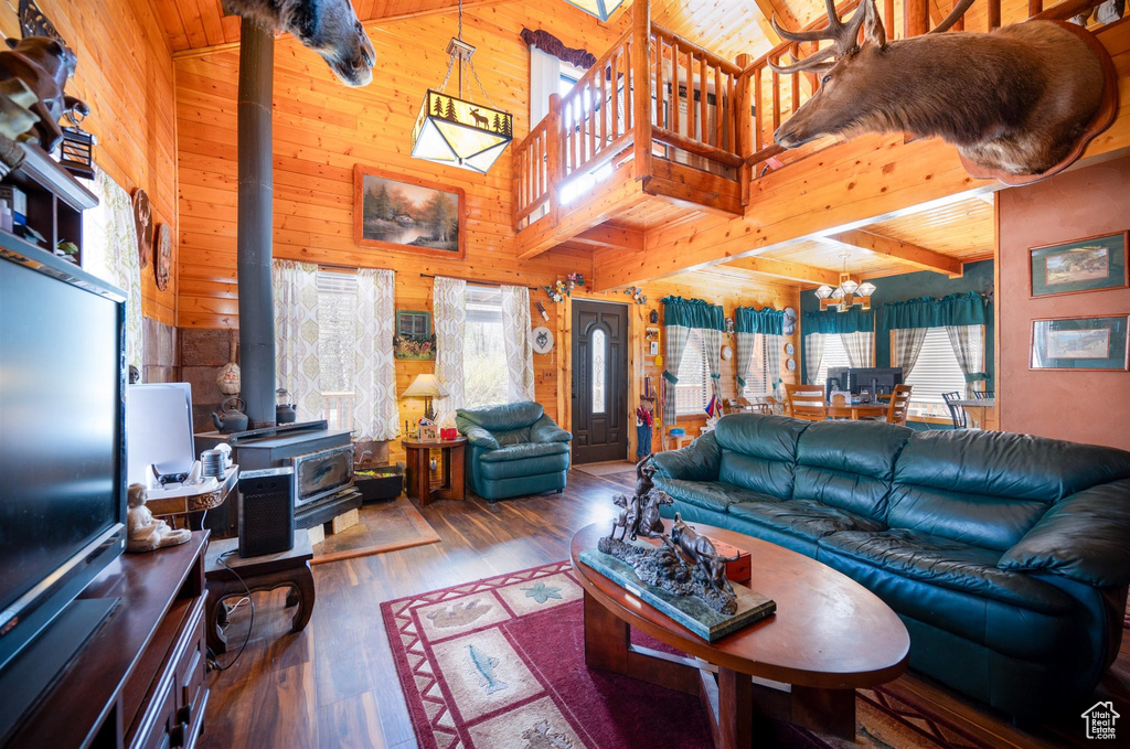 Living room featuring wooden ceiling, high vaulted ceiling, a wood stove, and wood-type flooring