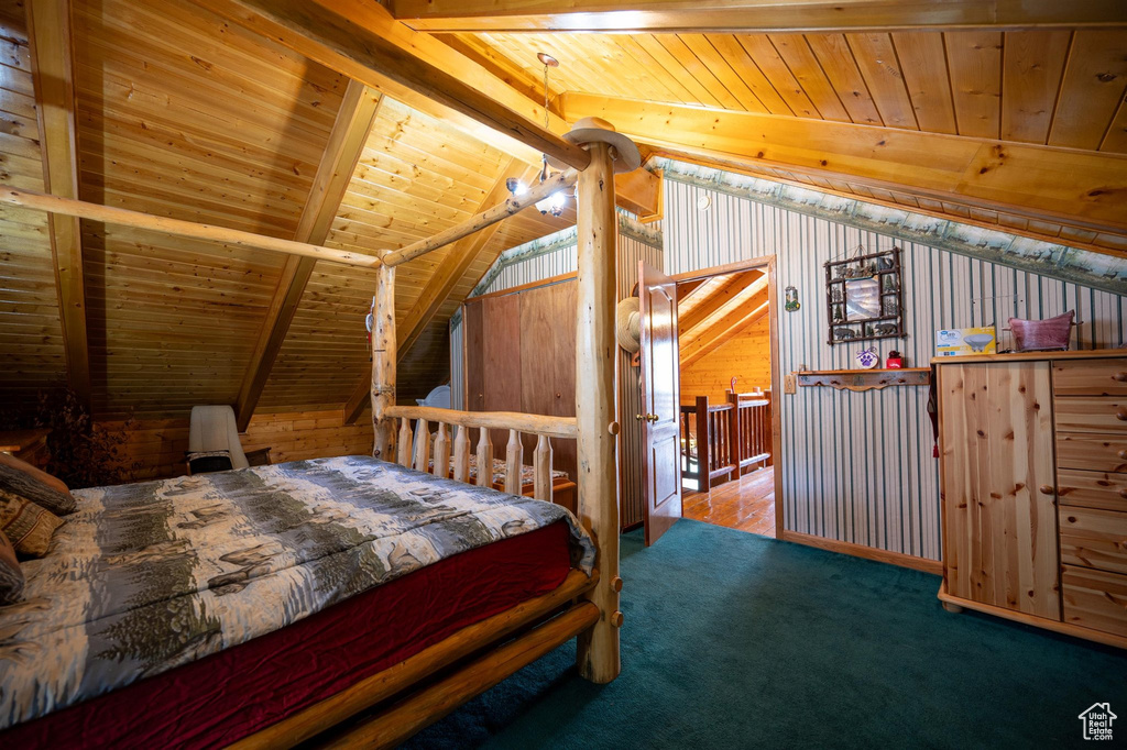 Carpeted bedroom featuring wooden ceiling, lofted ceiling with beams, and wood walls