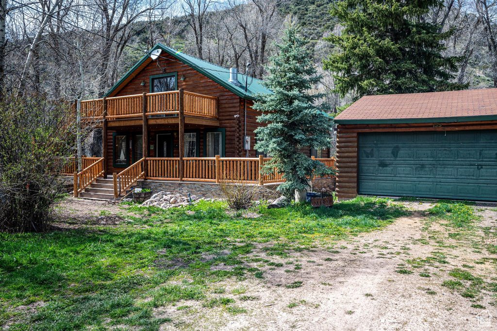 Rear view of house featuring a wooden deck and a balcony