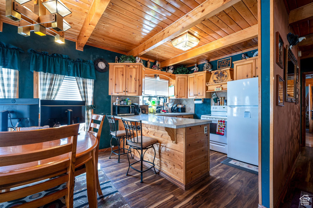 Kitchen featuring white appliances, dark wood-type flooring, beam ceiling, and wood ceiling