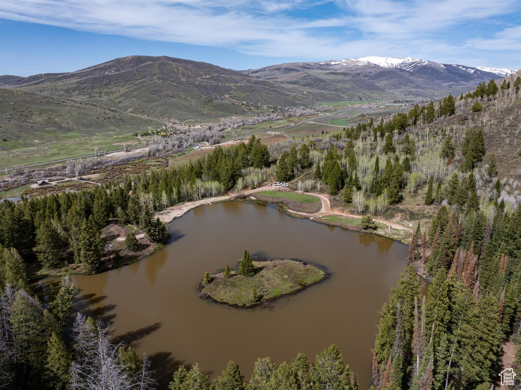 Birds eye view of property with a water and mountain view