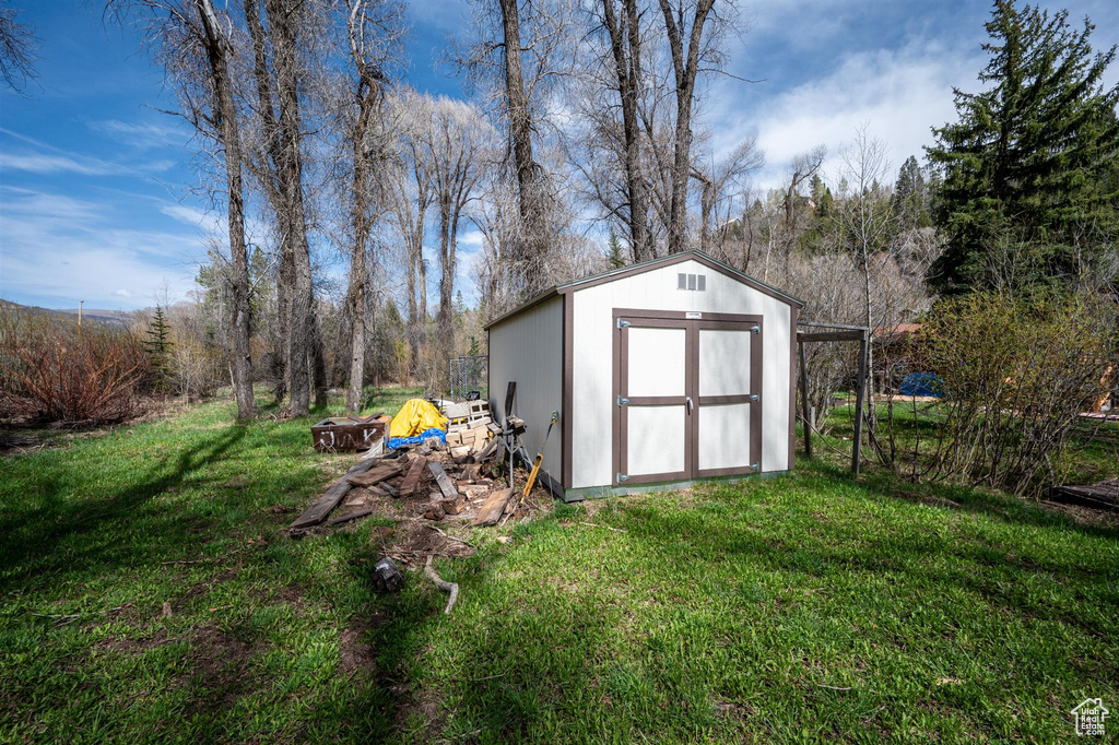 View of outdoor structure with a yard