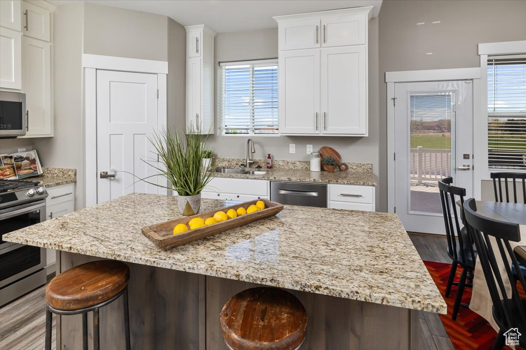 Kitchen featuring a center island, a healthy amount of sunlight, and a kitchen bar