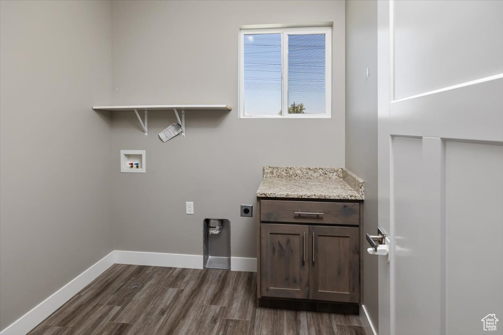 Laundry area with dark hardwood / wood-style floors, hookup for a washing machine, and hookup for an electric dryer