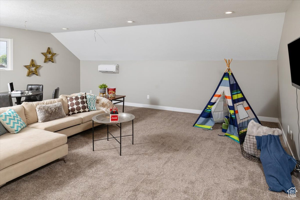 Living room with a wall mounted air conditioner, carpet, and lofted ceiling