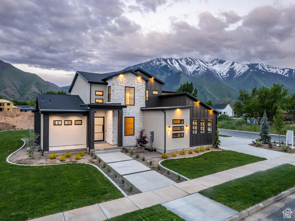 Modern farmhouse style home featuring a front yard and a mountain view