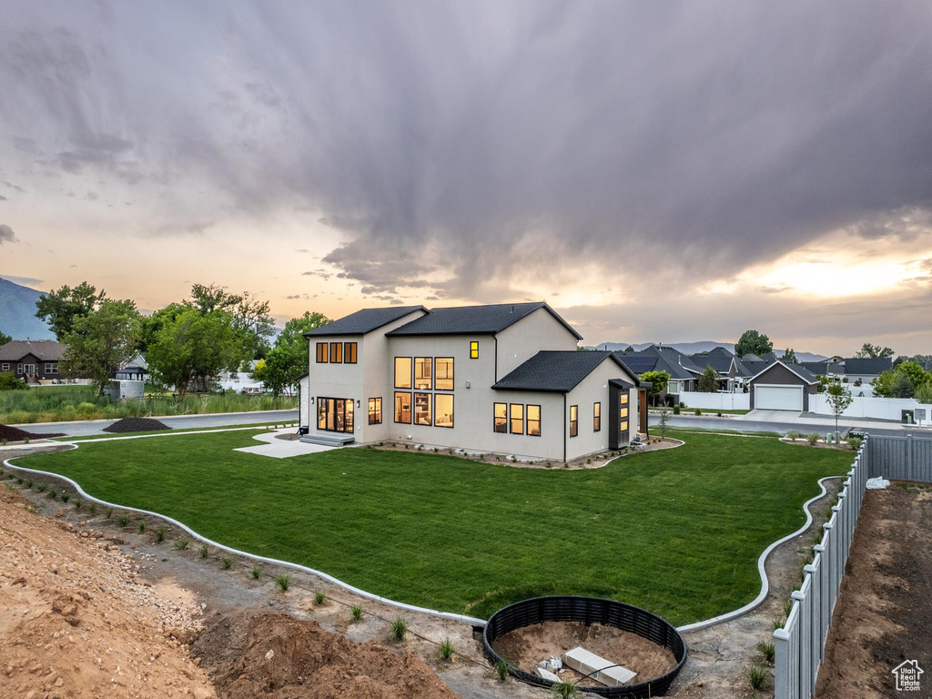 View of front of house featuring a garage and a lawn