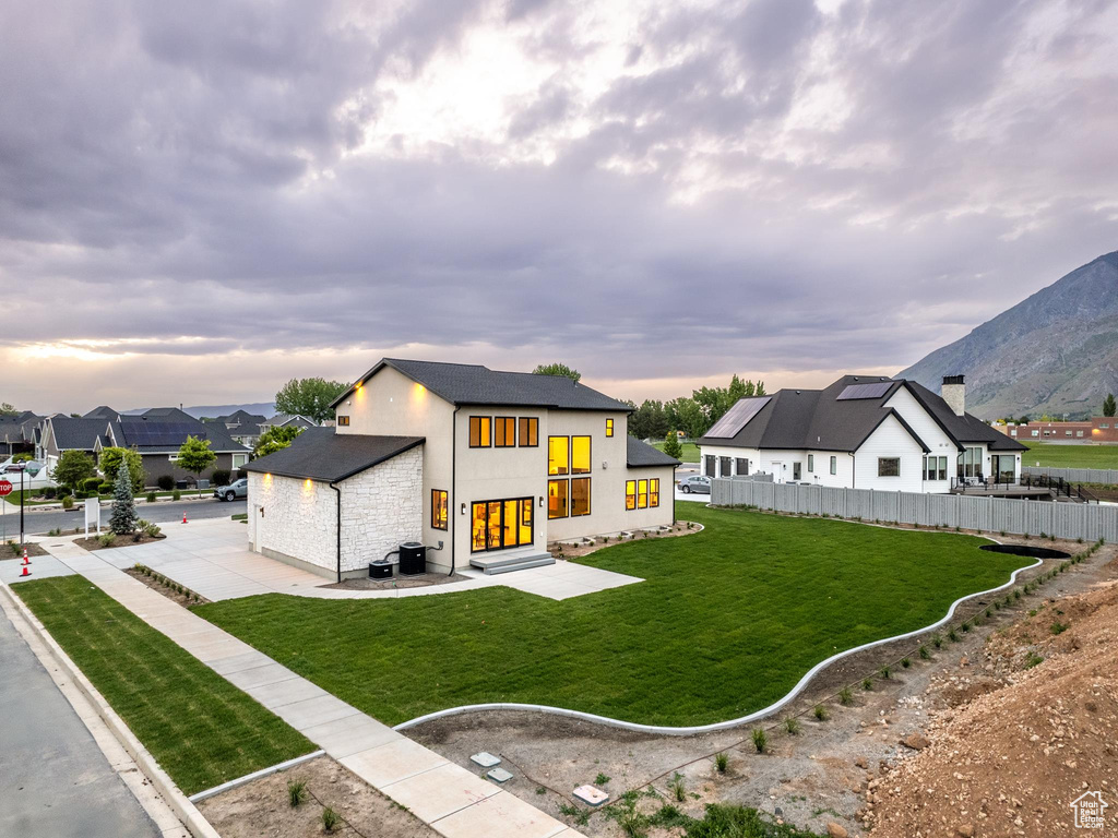 View of front facade with a yard, a mountain view, and a patio area