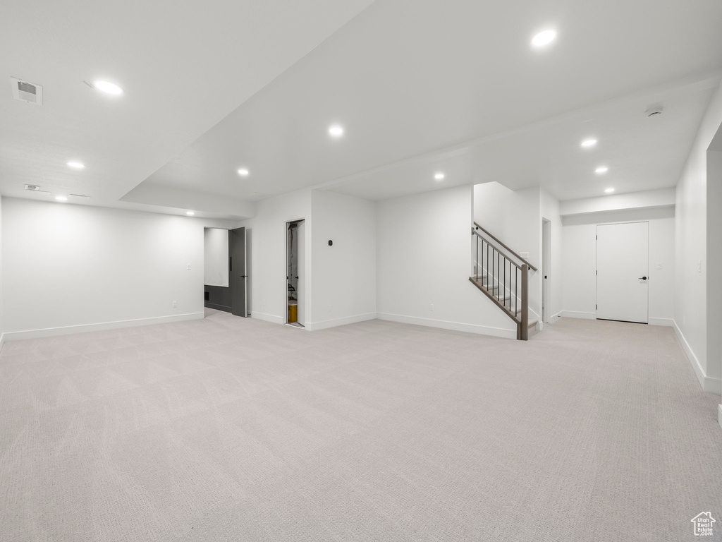 Basement featuring light colored carpet