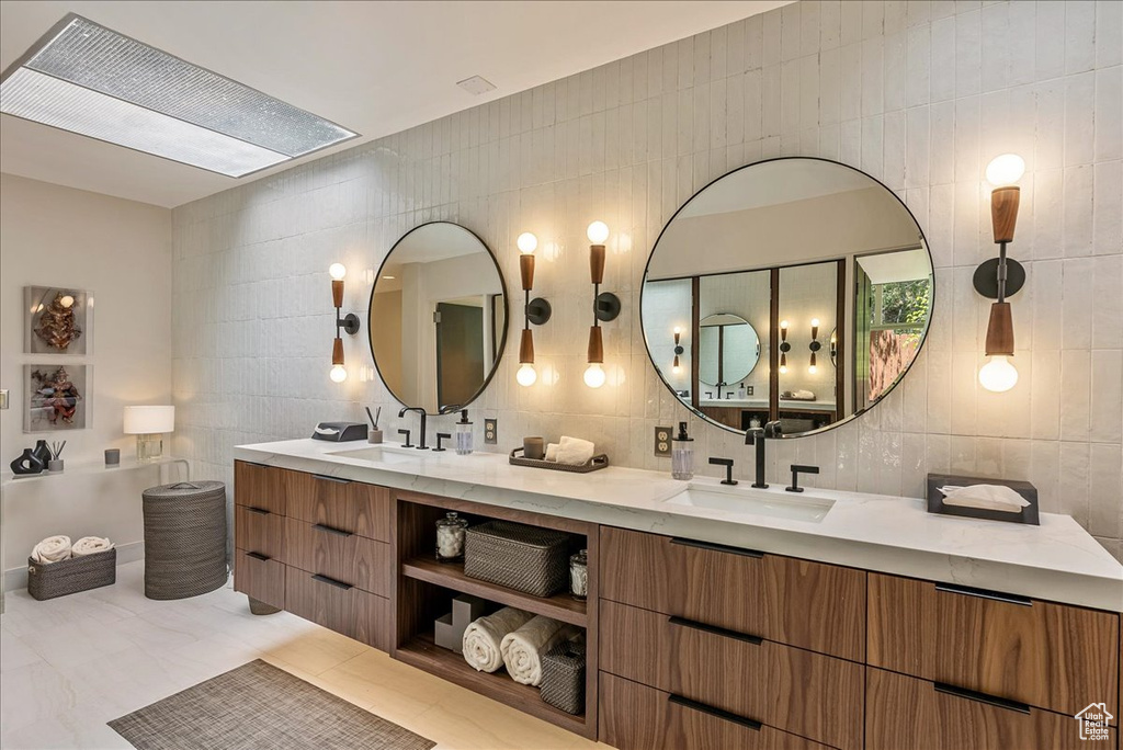 Bathroom with tile walls, tile floors, backsplash, and double vanity