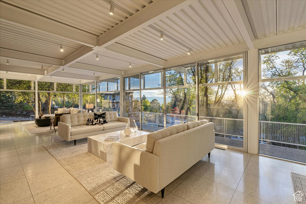 Sunroom / solarium featuring beam ceiling and rail lighting