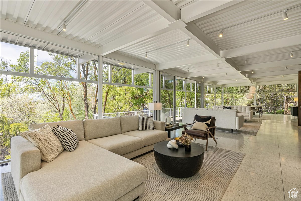 Sunroom featuring beamed ceiling and track lighting