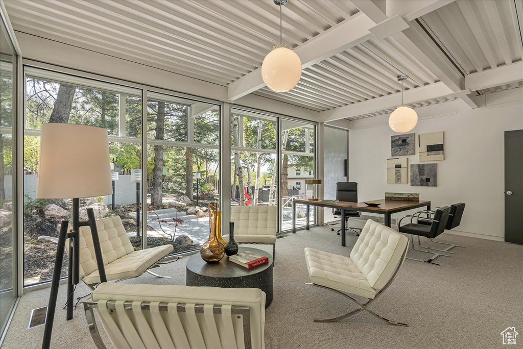 Sunroom featuring a healthy amount of sunlight and beam ceiling