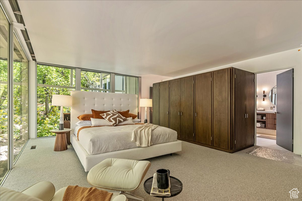 Bedroom with light colored carpet and multiple windows