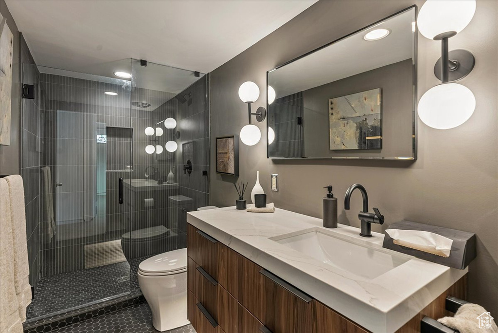 Bathroom with a shower with door, vanity, and toilet