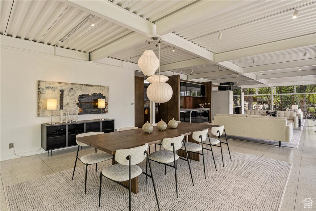 Tiled dining area with beamed ceiling and track lighting