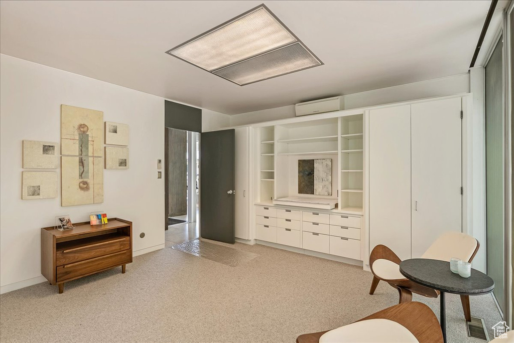 Interior space featuring light carpet and a wall unit AC