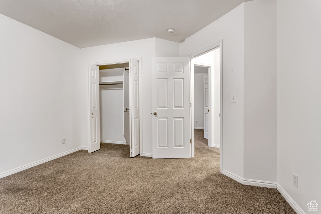 Unfurnished bedroom featuring carpet and a closet