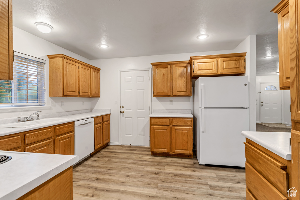 Kitchen featuring white appliances, sink, and light hardwood / wood-style floors