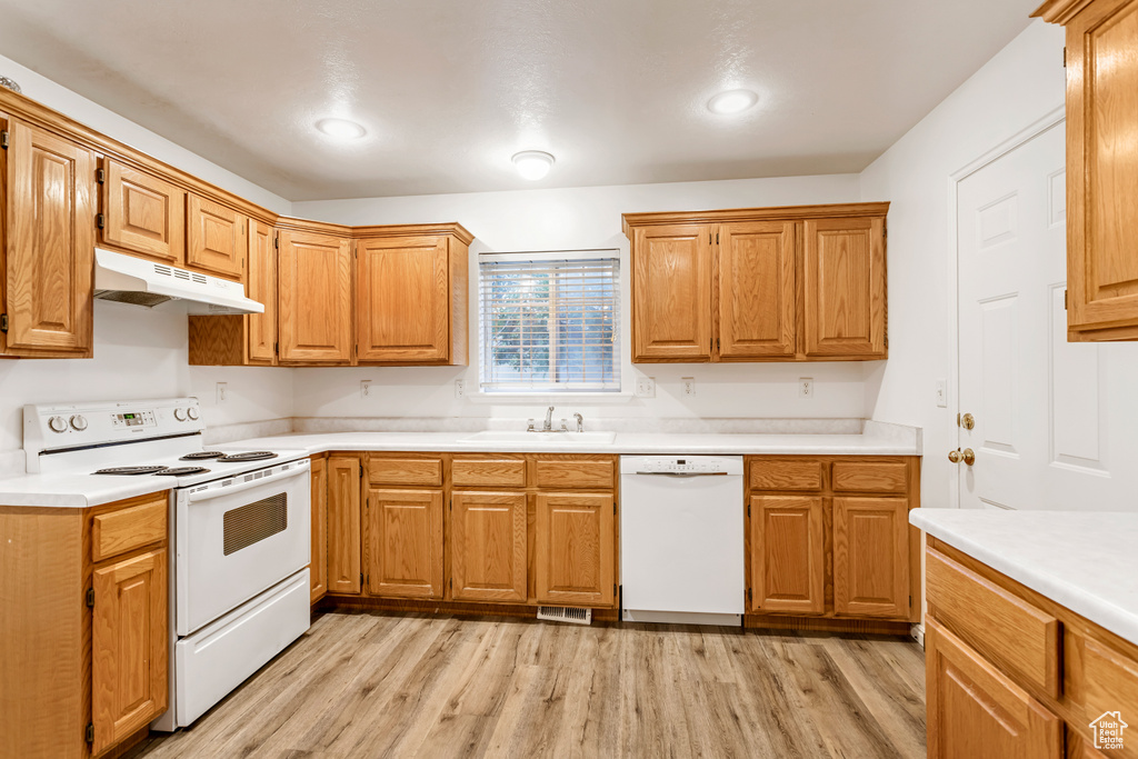 Kitchen with white appliances, sink, and light hardwood / wood-style flooring