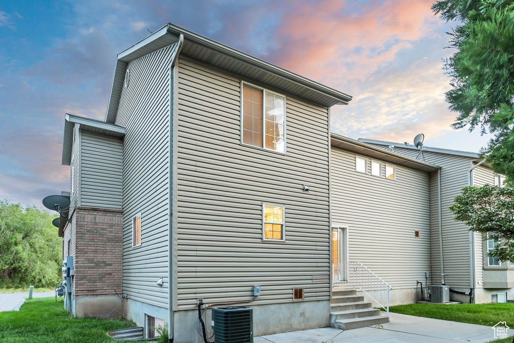 Back house at dusk featuring central AC