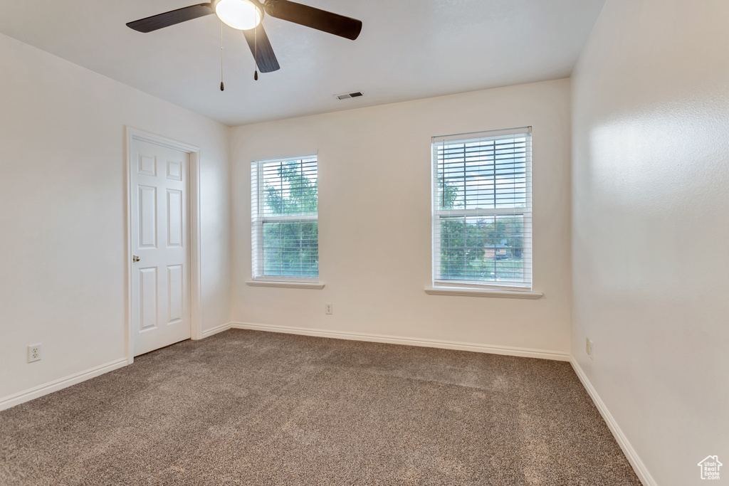 Empty room with carpet floors and ceiling fan