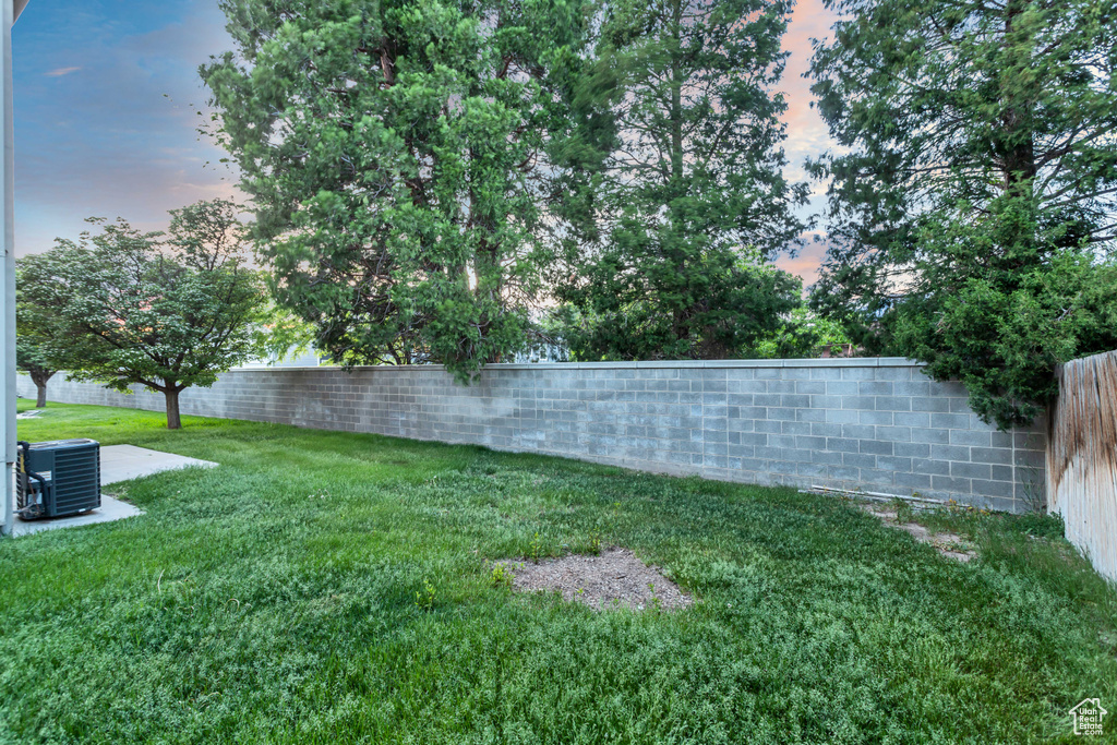 Yard at dusk featuring central AC