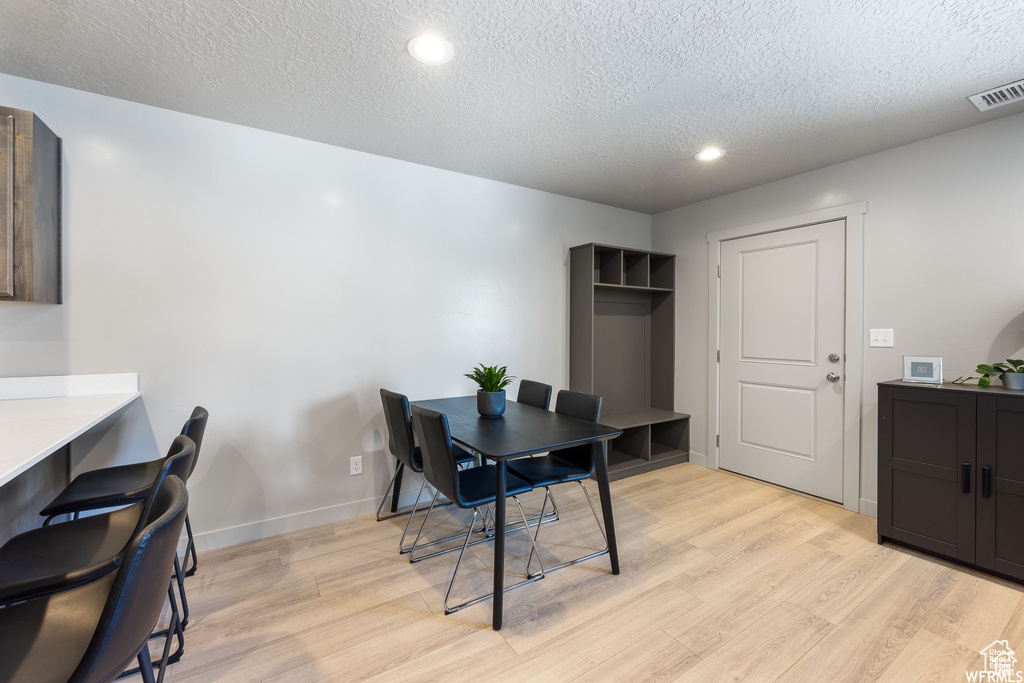 Dining area featuring light hardwood / wood-style floors and a textured ceiling