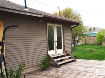 Wooden terrace featuring a yard and french doors