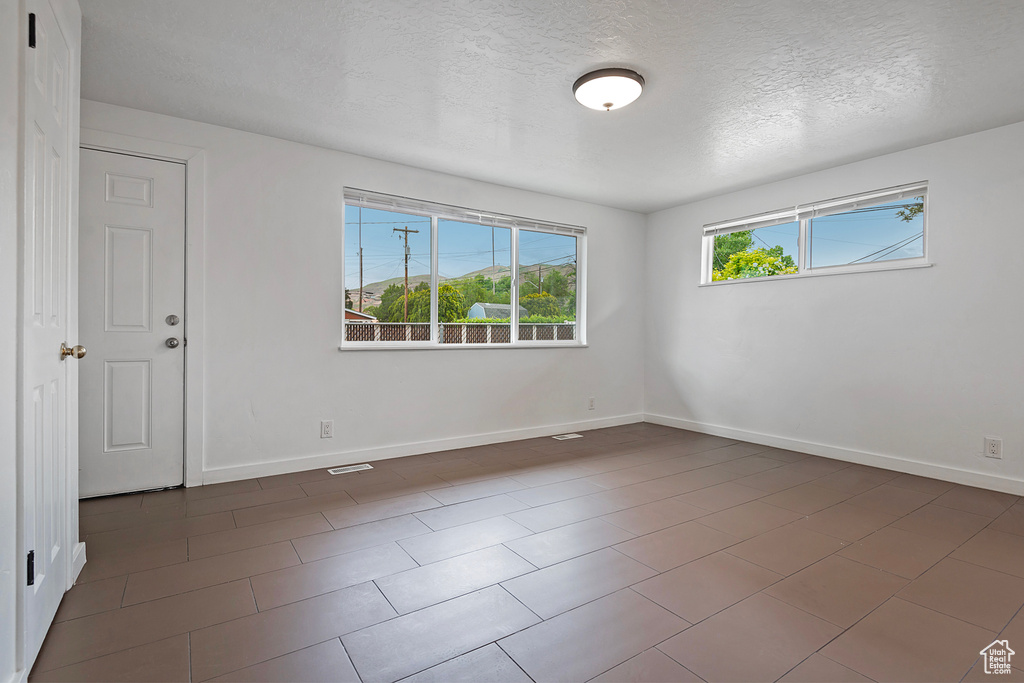 Tiled spare room with a textured ceiling