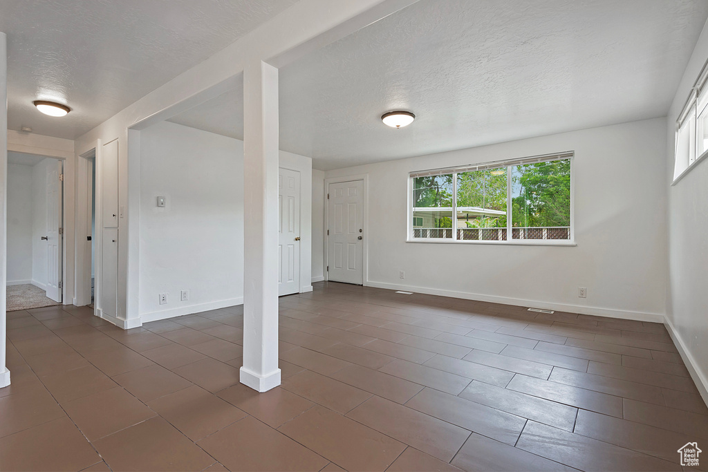 Unfurnished room with dark tile flooring