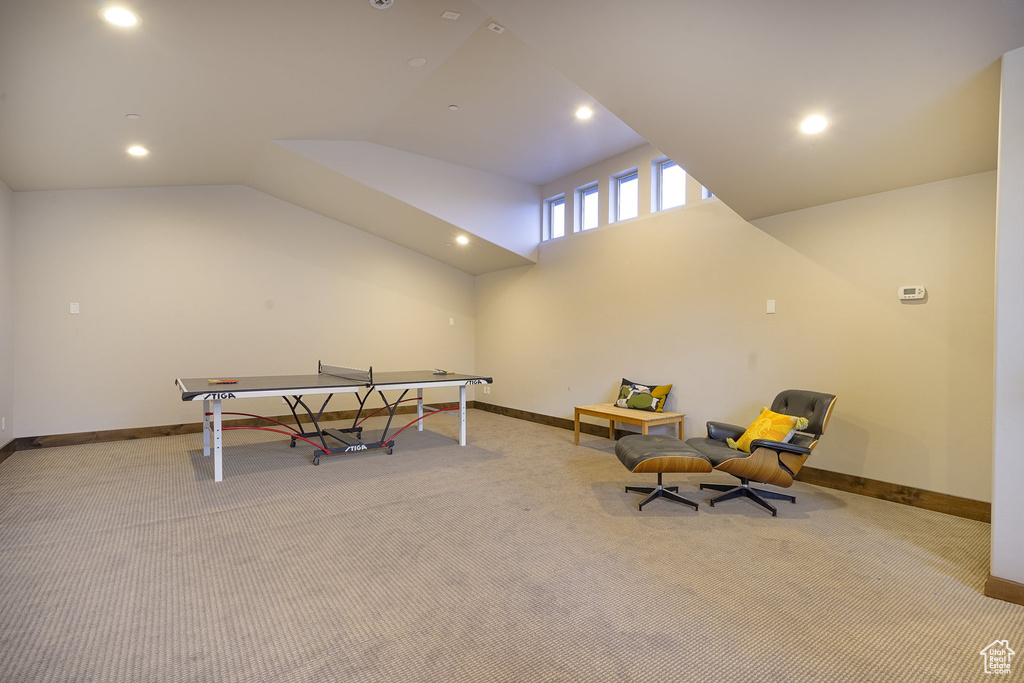Rec room with carpet and vaulted ceiling