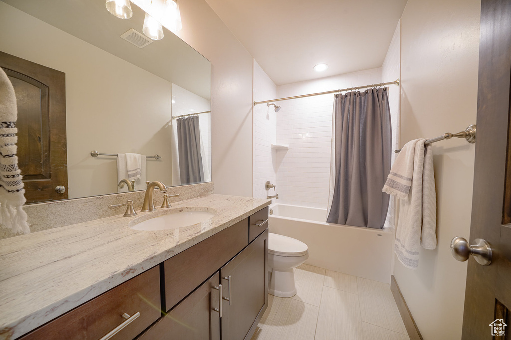 Full bathroom with tile flooring, shower / tub combo, toilet, and vanity with extensive cabinet space