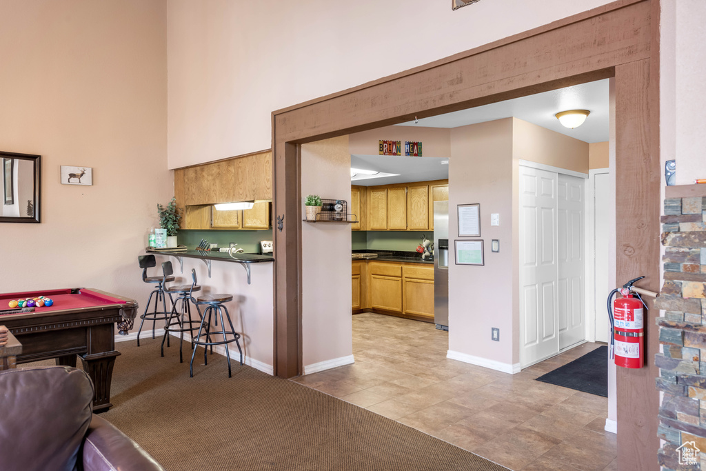 Kitchen featuring light colored carpet, billiards, and stainless steel fridge