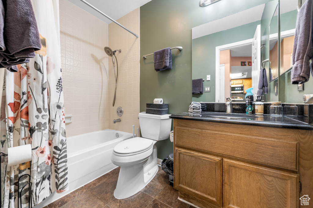 Full bathroom with shower / bathtub combination with curtain, tile flooring, vanity, and toilet