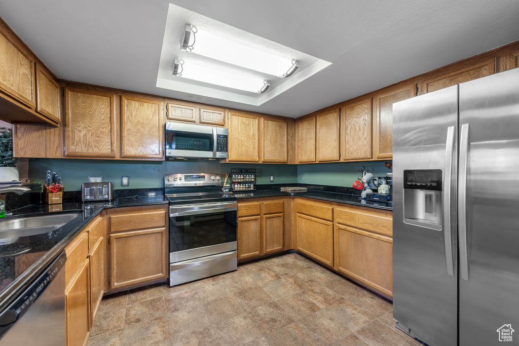 Kitchen featuring sink, light tile floors, and stainless steel appliances