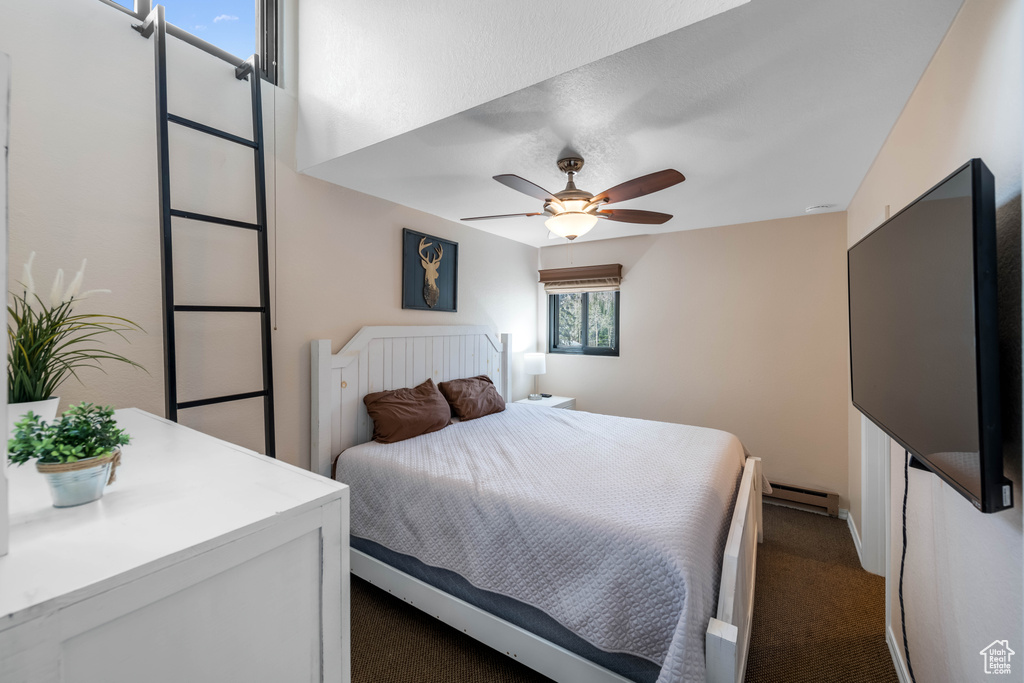 Carpeted bedroom featuring a baseboard radiator and ceiling fan