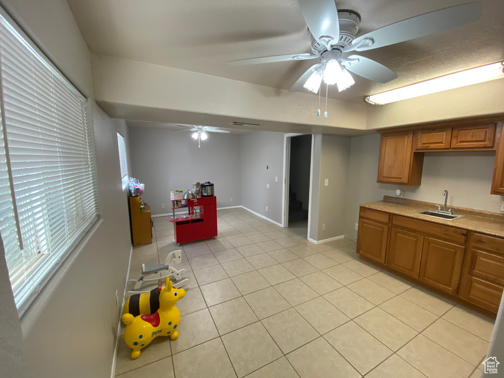 Kitchen featuring ceiling fan, light tile flooring, and sink