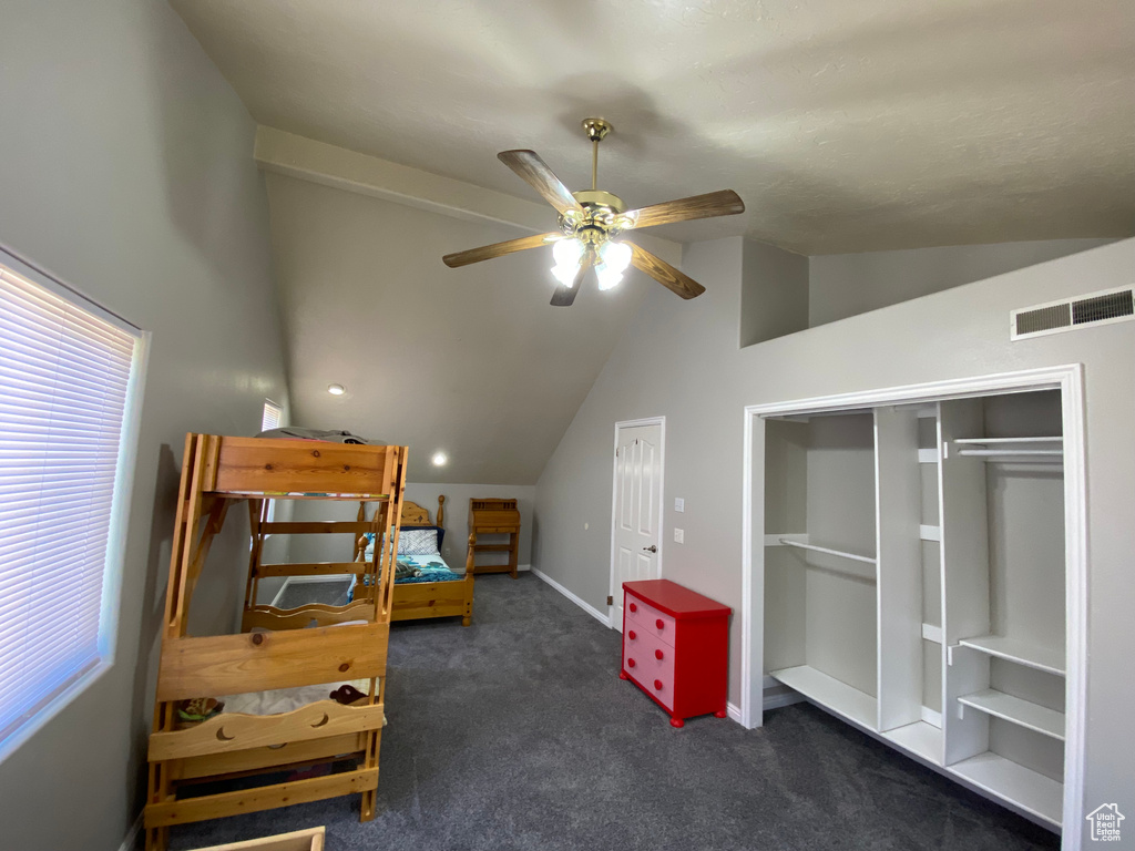 Bedroom with lofted ceiling, dark colored carpet, and ceiling fan